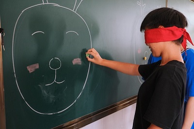 捏着鼻子原地旋转三圈,然后尝试着依靠记忆将手中的"鼻子"贴在黑板上